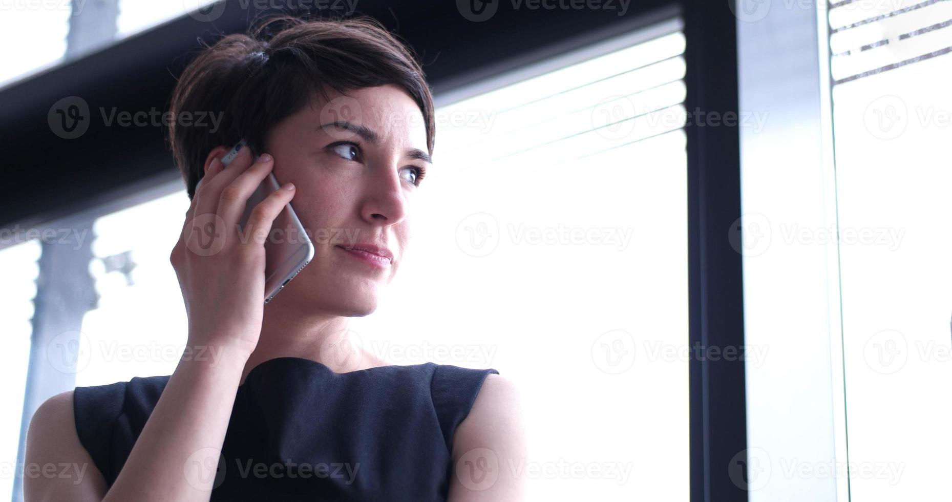 Business Girl Standing In A Modern Building Near The Window With Phone photo