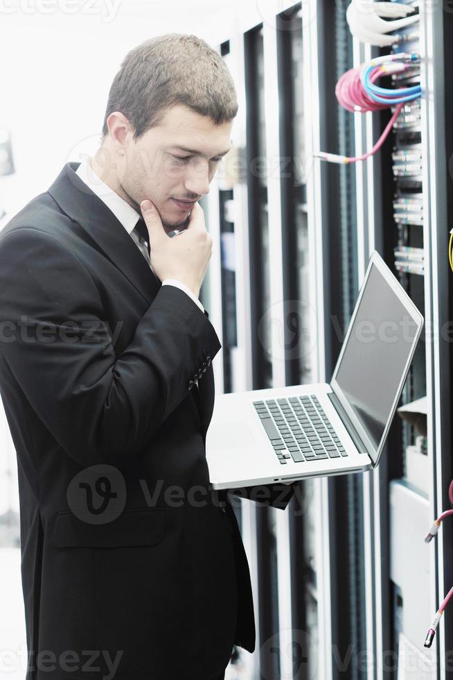 businessman with laptop in network server room photo