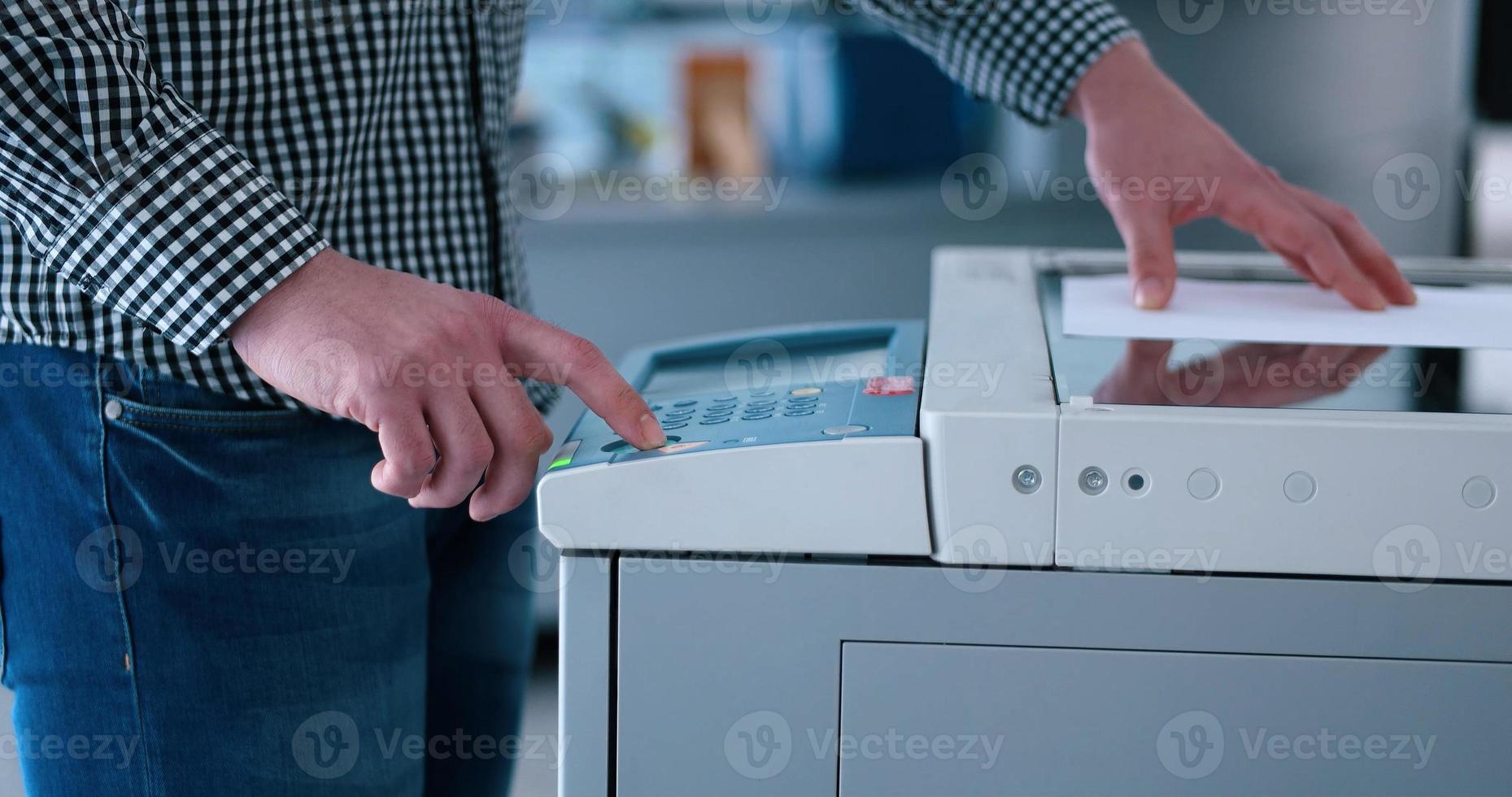 Male Assistant Using Copy Machine in modern office photo