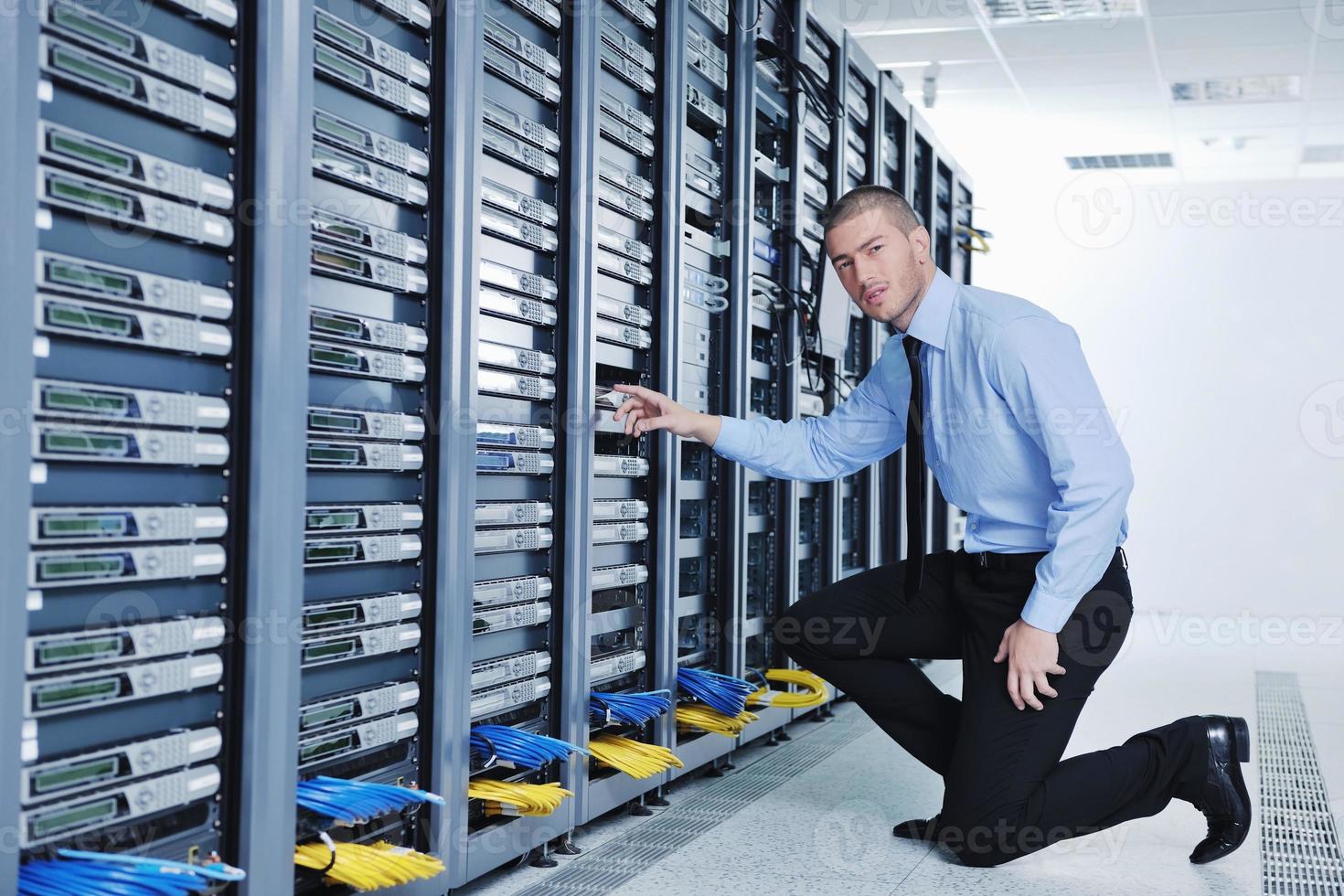 young it engineer in datacenter server room photo