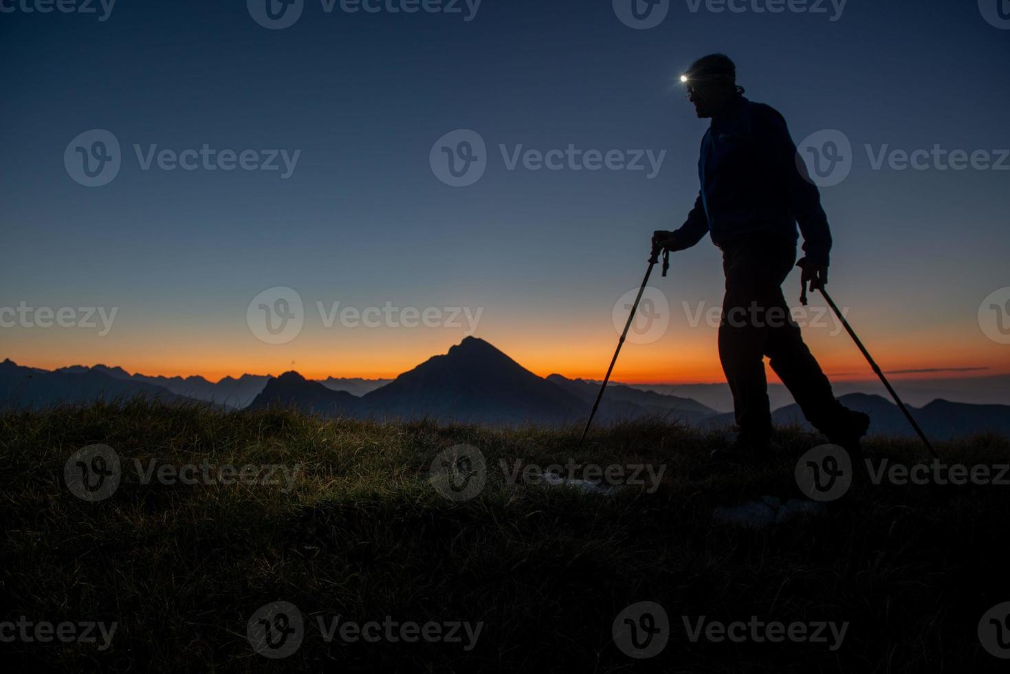 Early morning hiker walking with flashlight on head photo