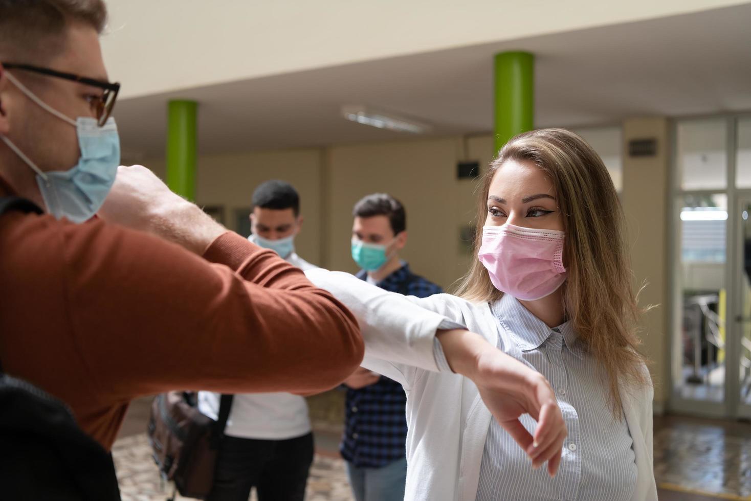 estudiantes saludando el nuevo apretón de manos normal de coronavirus y golpes de codo foto