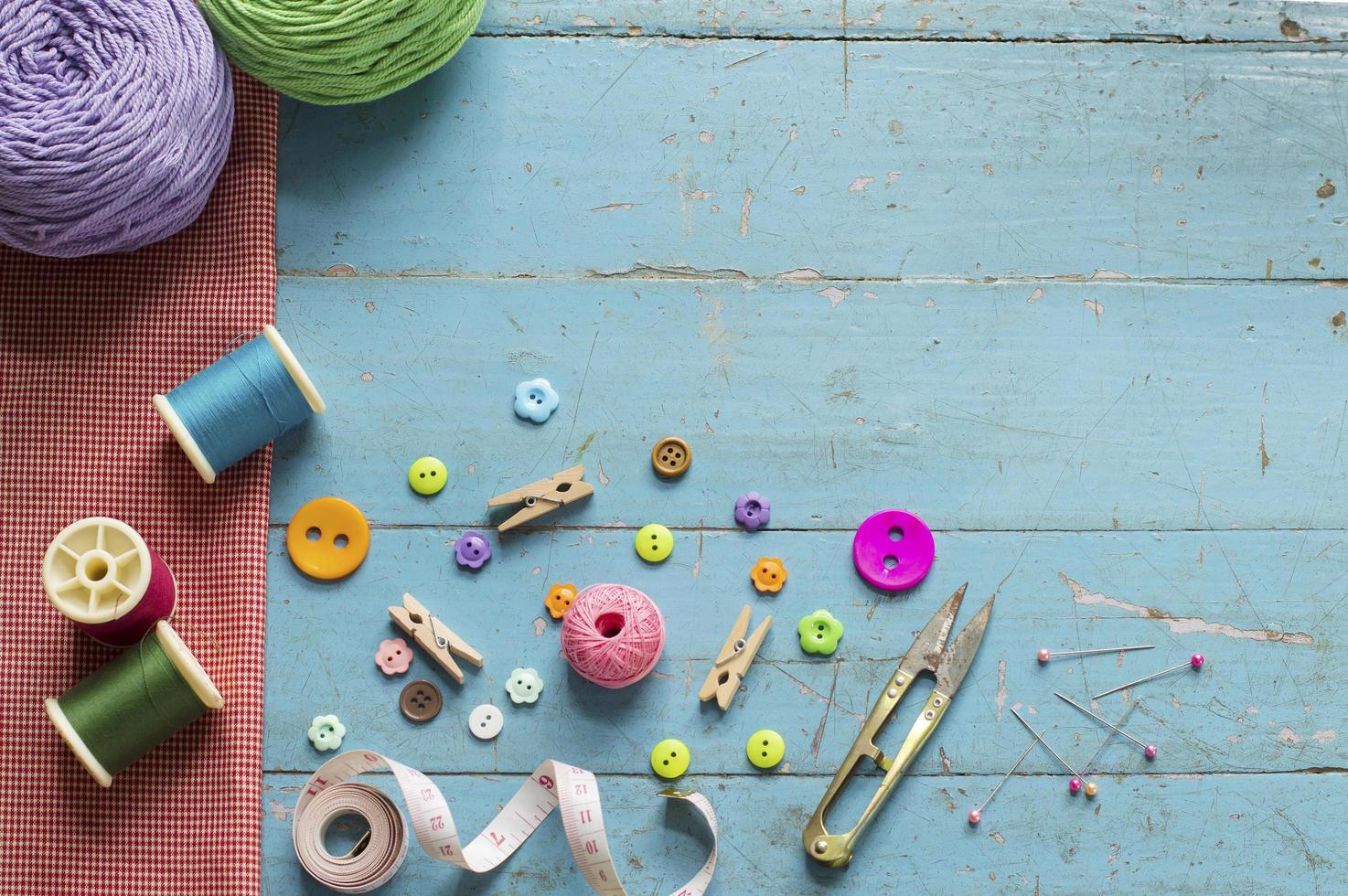 Sewing background. Accessories for needlework on old wooden background. photo