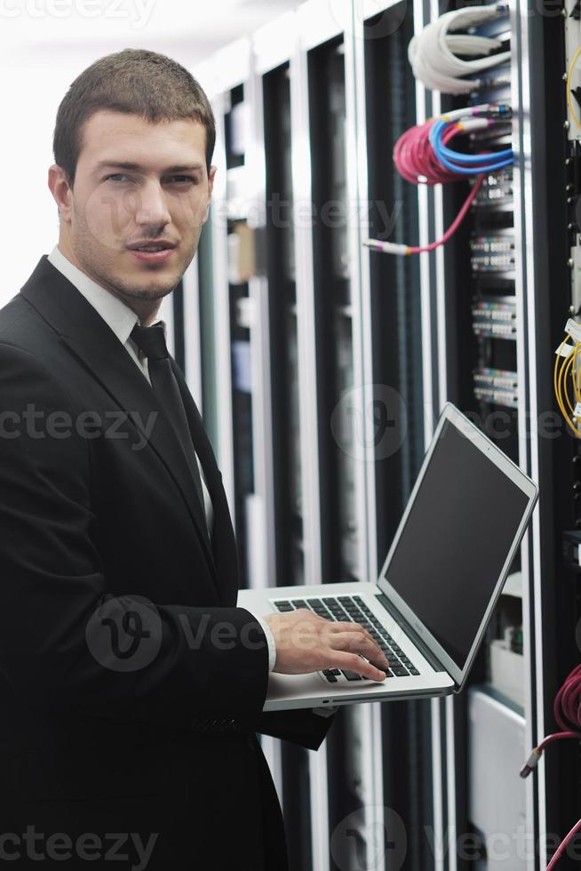 businessman with laptop in network server room photo