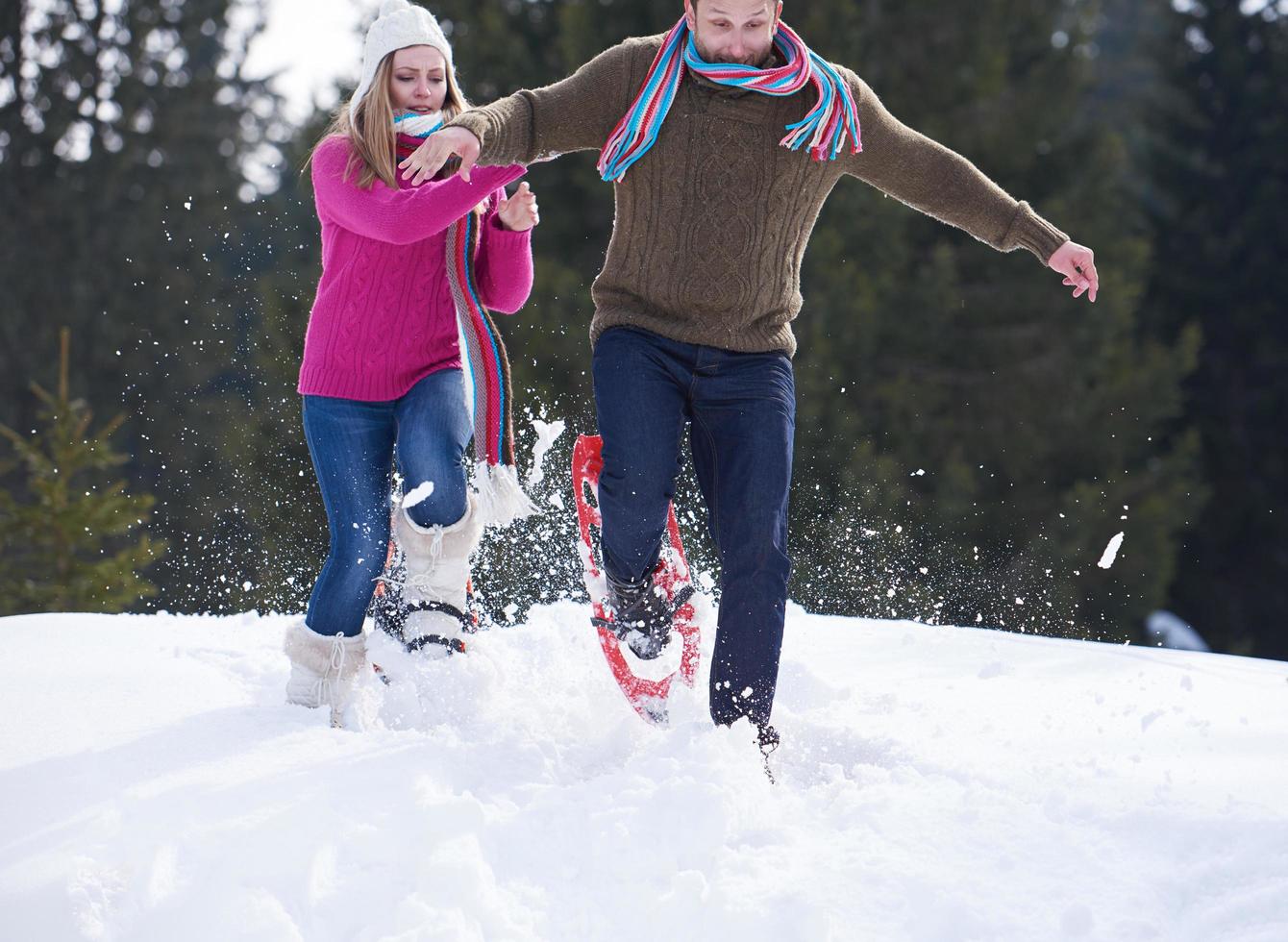 couple having fun and walking in snow shoes photo