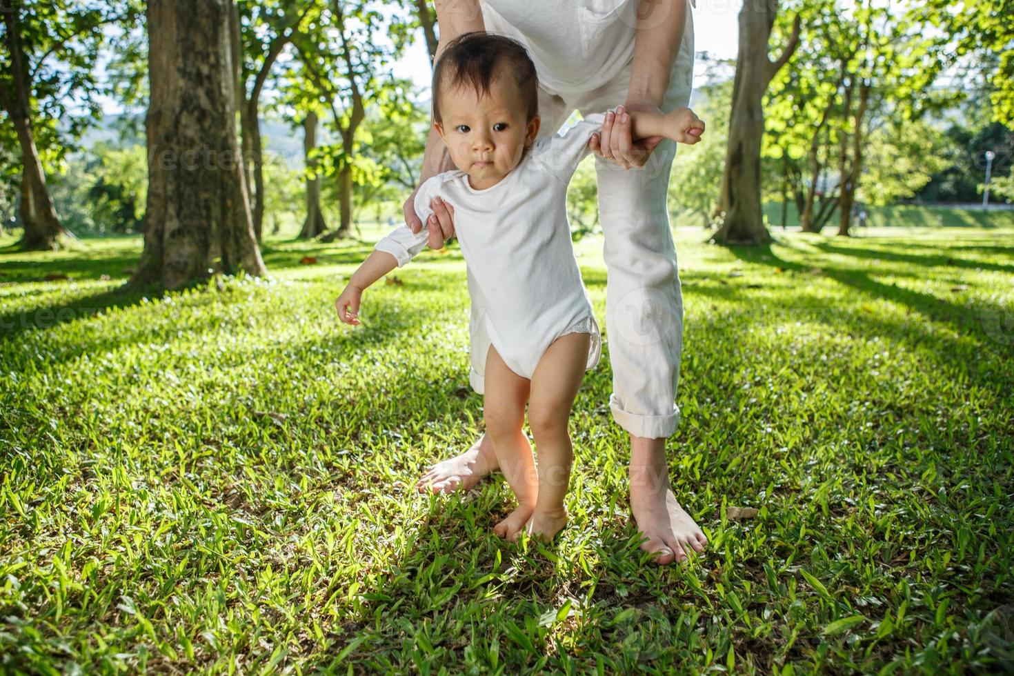 Legs of mother and baby. First steps. photo