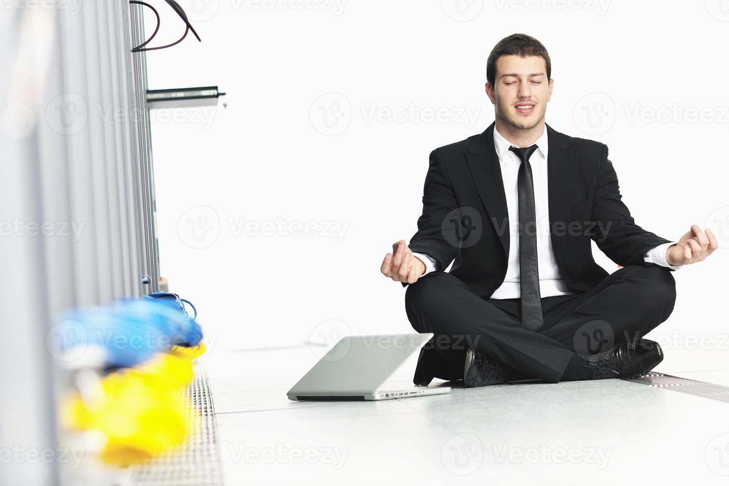 hombre de negocios practica yoga en la sala de servidores de red foto