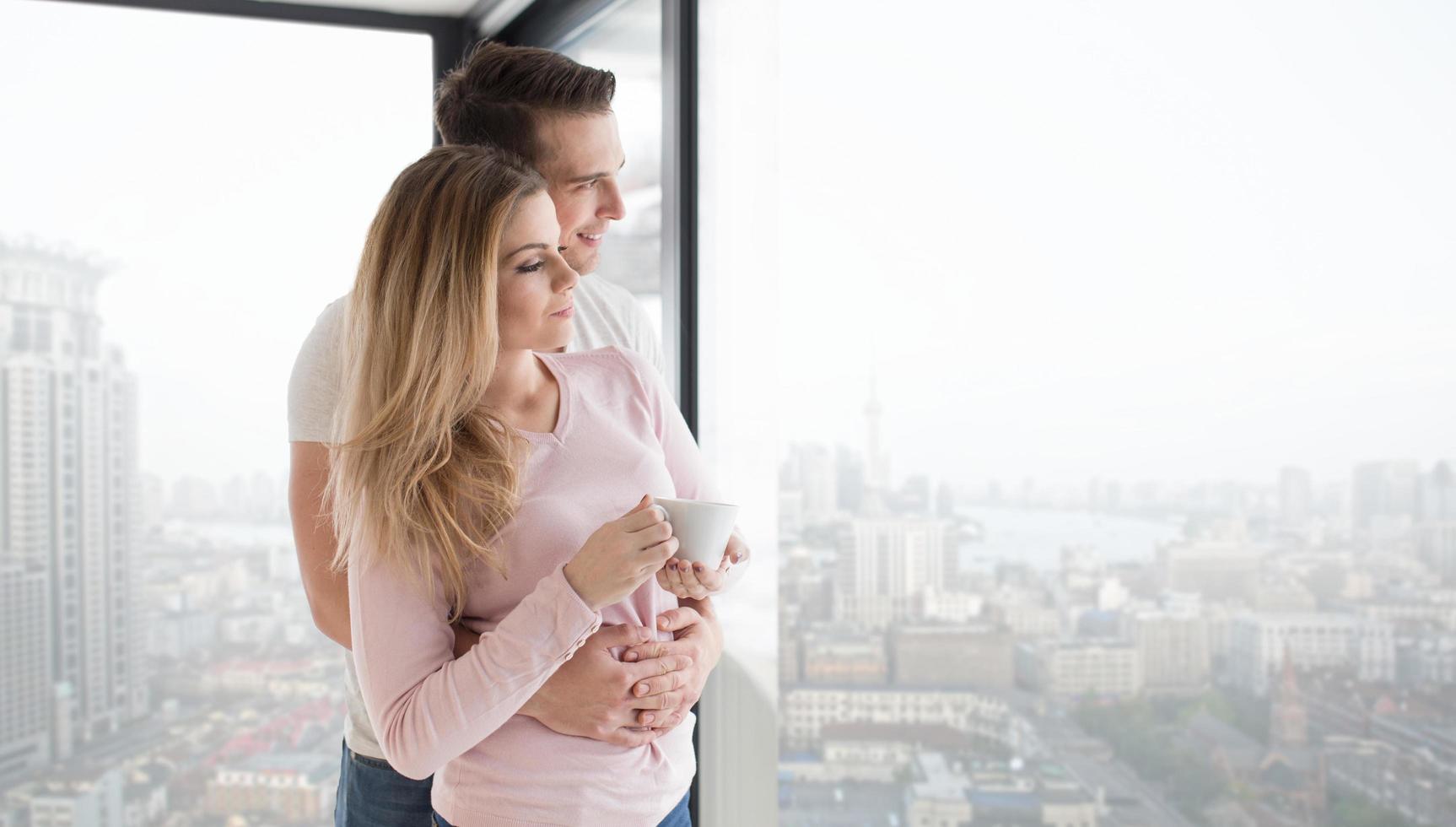 pareja joven disfrutando del café matutino junto a la ventana foto