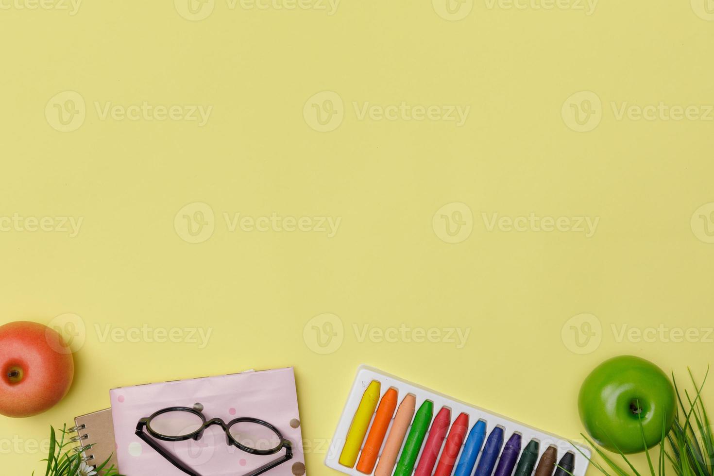 flatlay creativo de educación mesa amarilla con libros para estudiantes, crayón colorido, anteojos, espacio vacío aislado en fondo amarillo, concepto de educación y regreso a la escuela foto