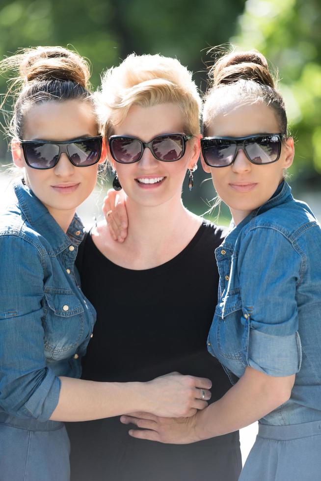 portrait of three young beautiful woman with sunglasses photo