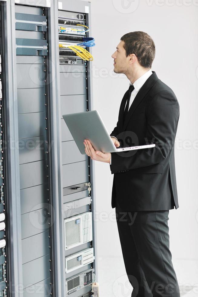 businessman with laptop in network server room photo