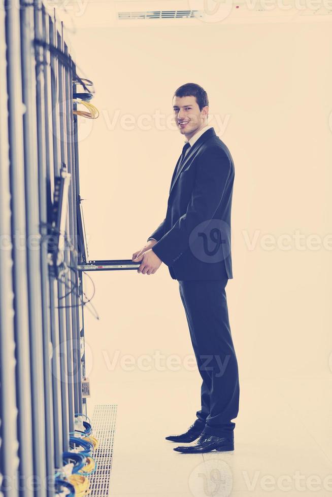 young engeneer in datacenter server room photo