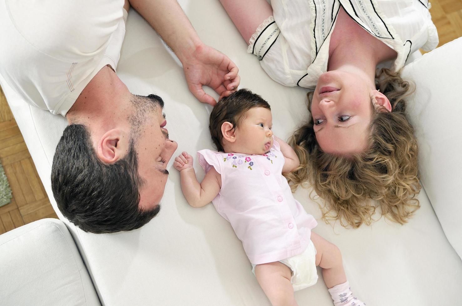 retrato interior con una familia joven feliz y un lindo bebé foto