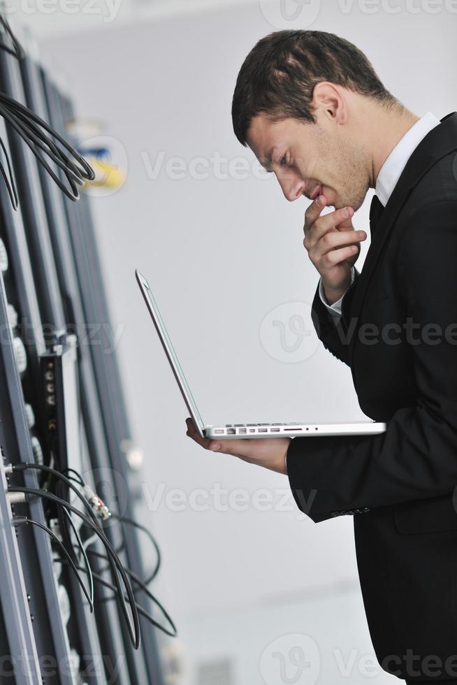 businessman with laptop in network server room photo