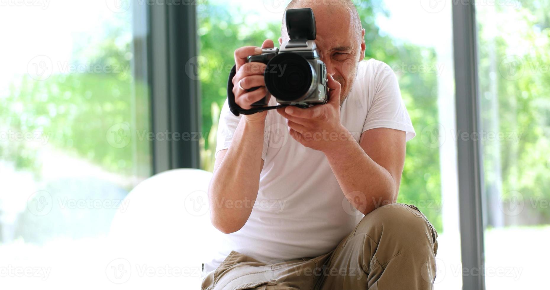 Photographer takes pictures with DSLR camera photo