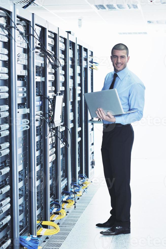 businessman with laptop in network server room photo