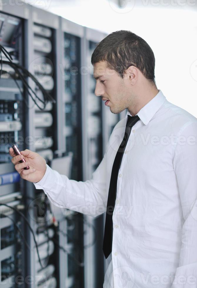 young engeneer in datacenter server room photo