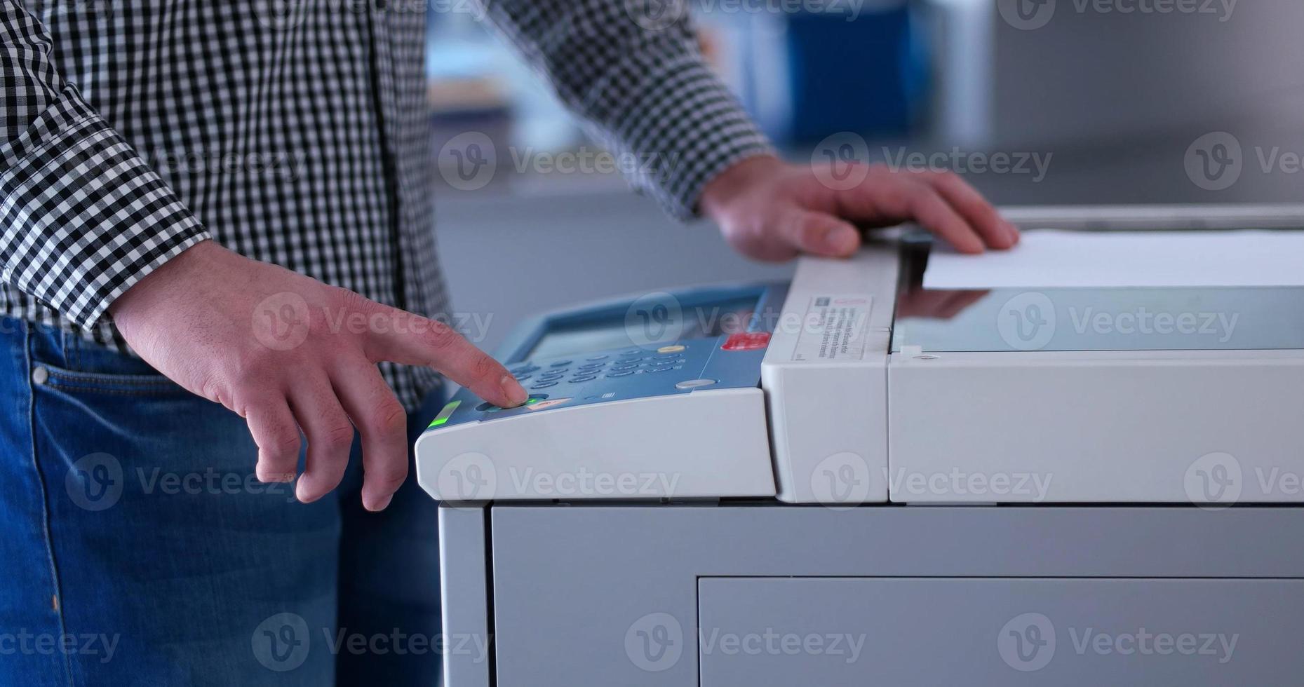 Male Assistant Using Copy Machine in modern office photo