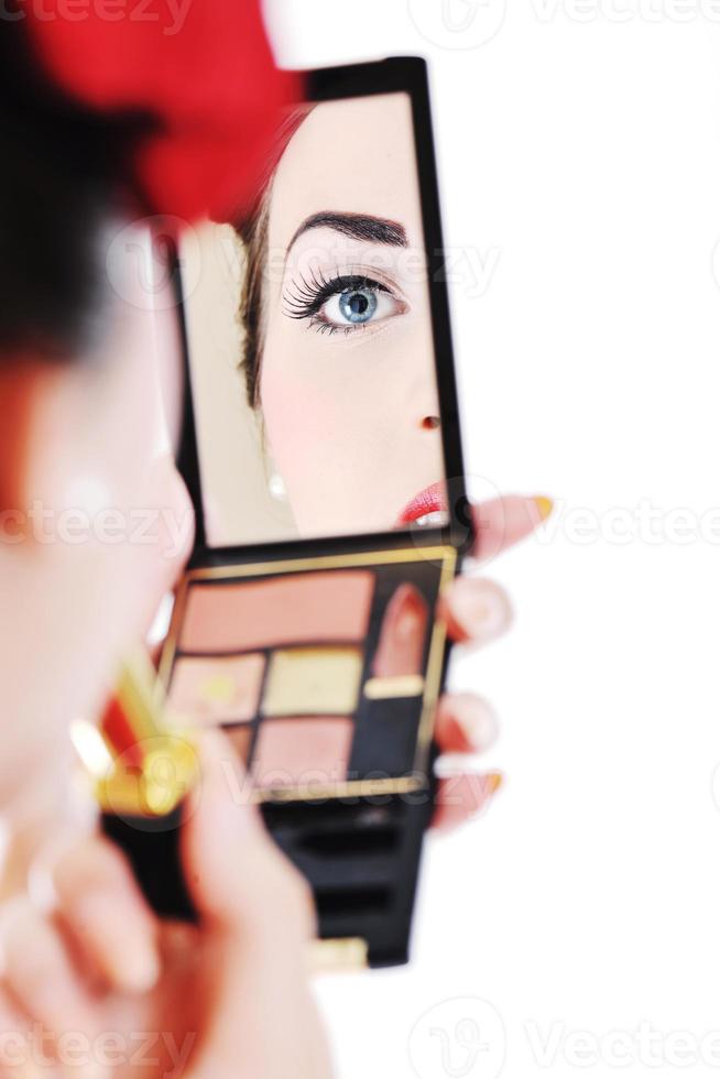 beautiful young woman applying makeup photo