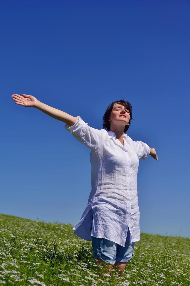 young woman with spreading arms to sky photo