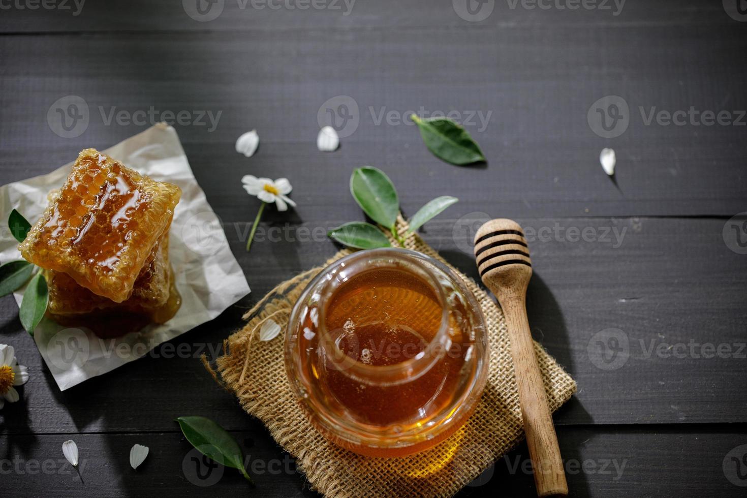 miel orgánica y panal en la mesa de madera, productos saludables por concepto de ingredientes naturales orgánicos foto