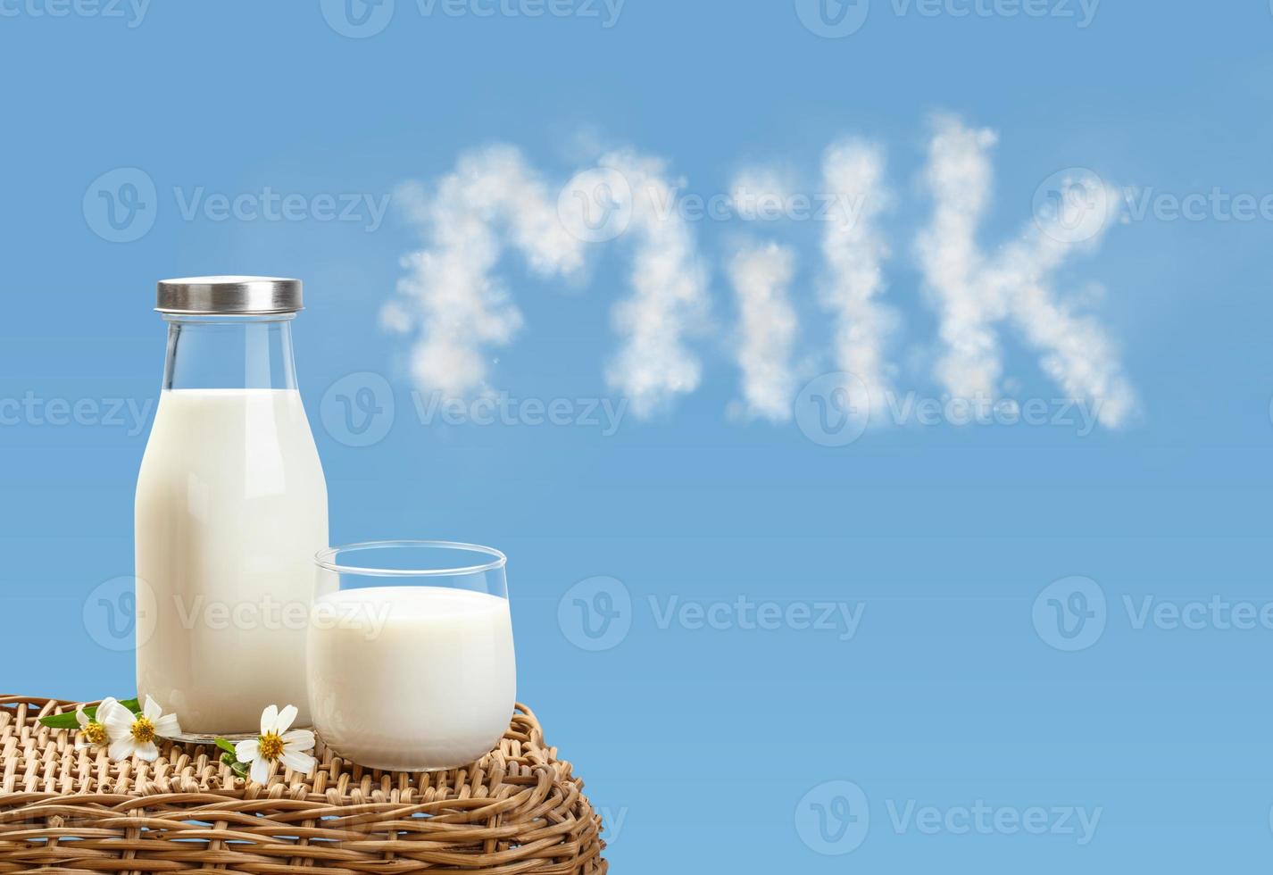 A bottle of rustic milk and glass of milk on wicker on a blue sky background, tasty, nutritious and healthy dairy products photo