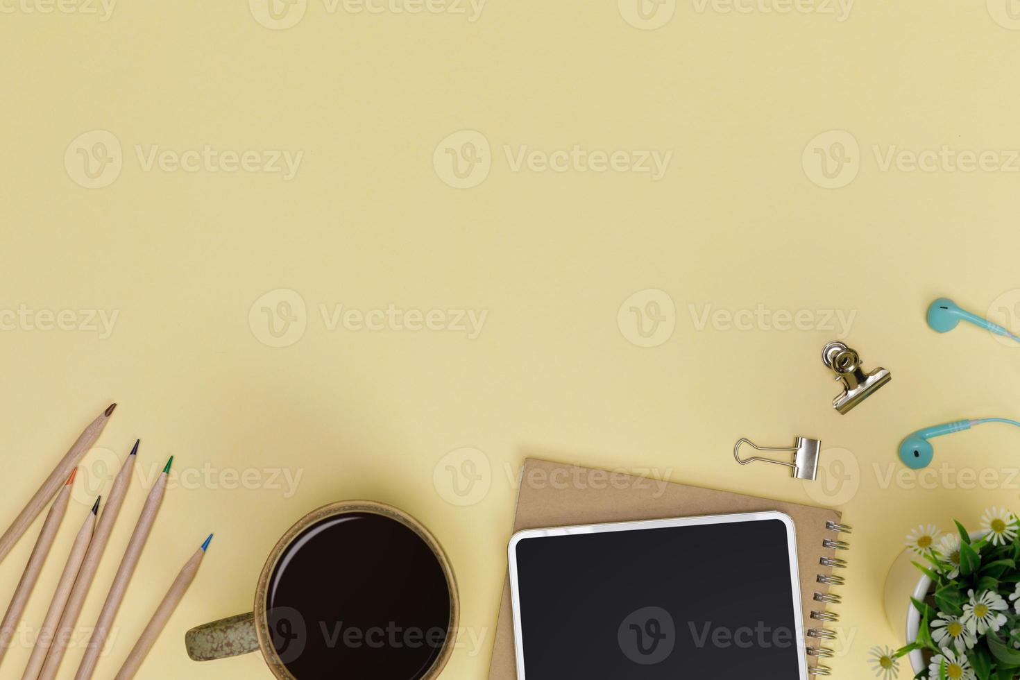 Creative flat lay of office supplies mockup with tablet, hot coffee cup, books and accessories isolated on yellow background, Top view with copy space, Workspace for freelancer concept photo