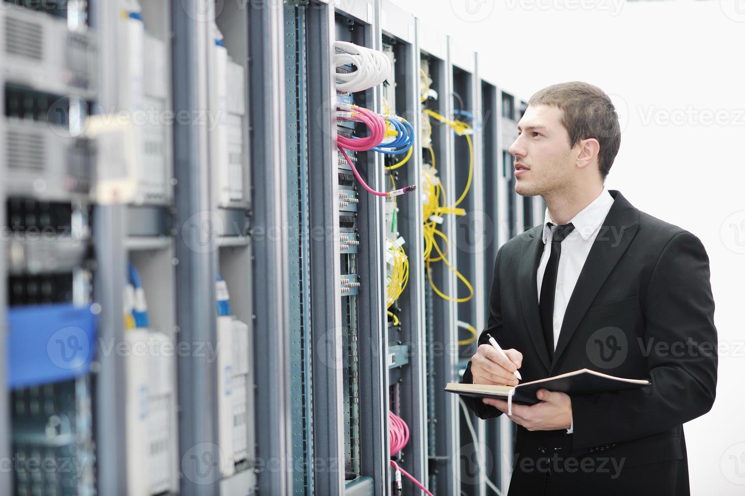 businessman with laptop in network server room photo