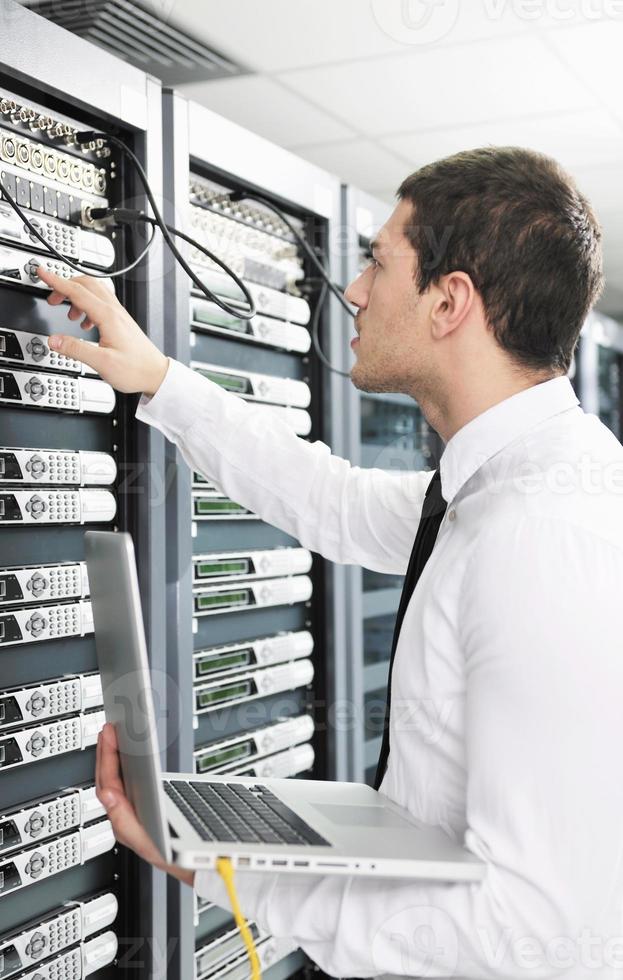 businessman with laptop in network server room photo