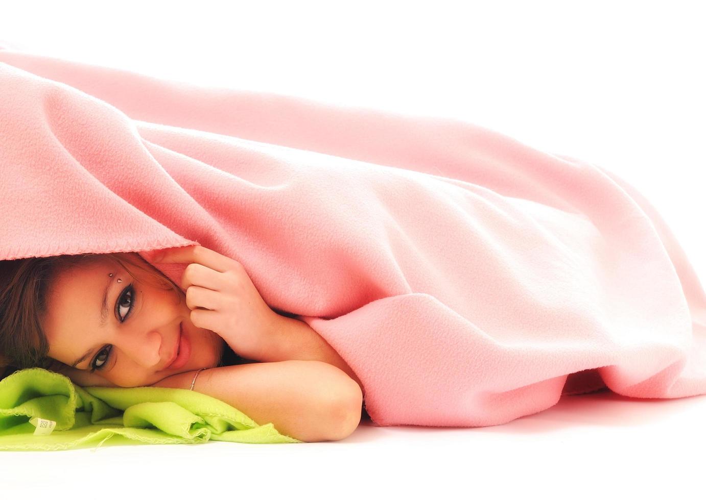 young girls under blanket smile photo