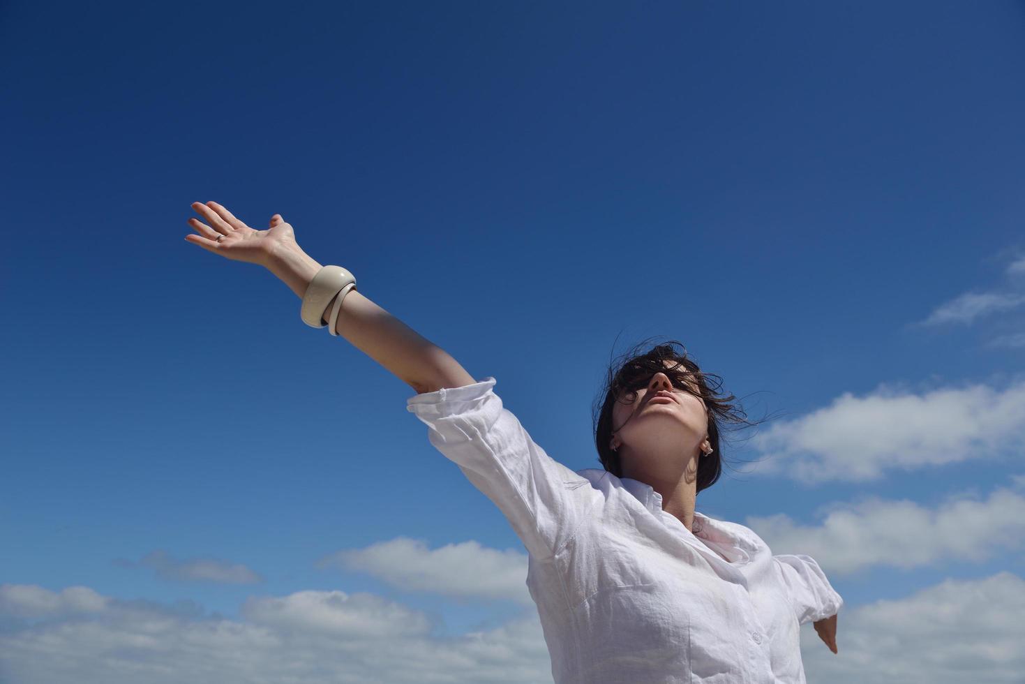 happy young woman with spreading arms to sky photo