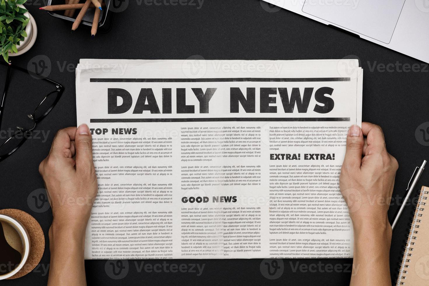 Hands holding Business Newspaper and office supplies with notebook, hot coffee cup, glasses, books and accessories on black desk topview, Daily Newspaper mockup concept photo