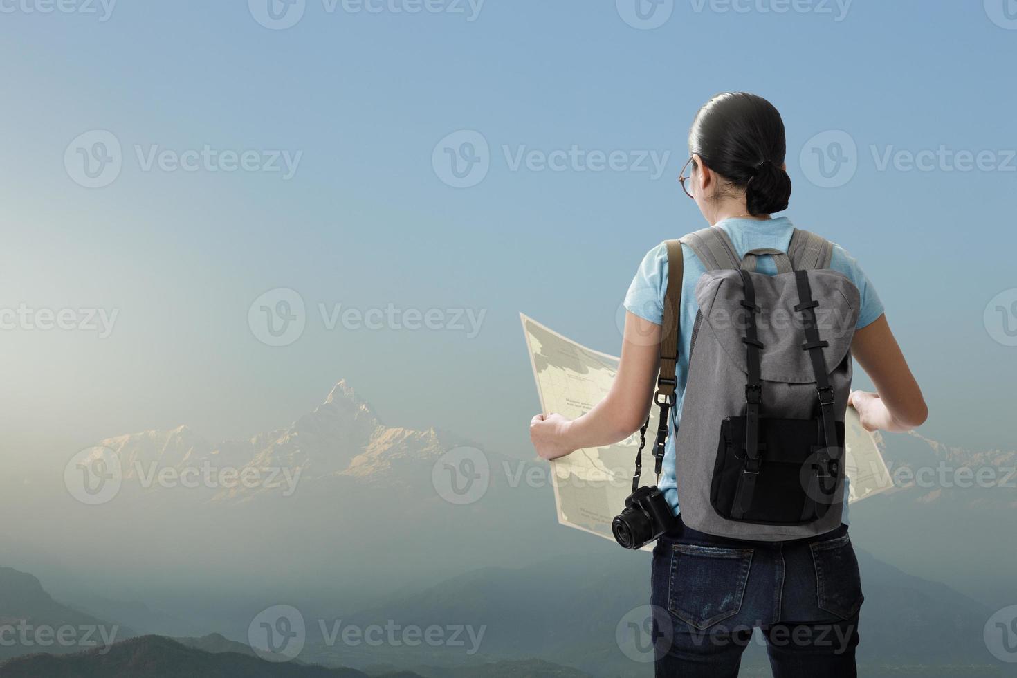 Travelling tourist with her backpack on the top of iceberg mountain in the nature and look searching direction on location map, Adventure and travel in the mountains region concept photo