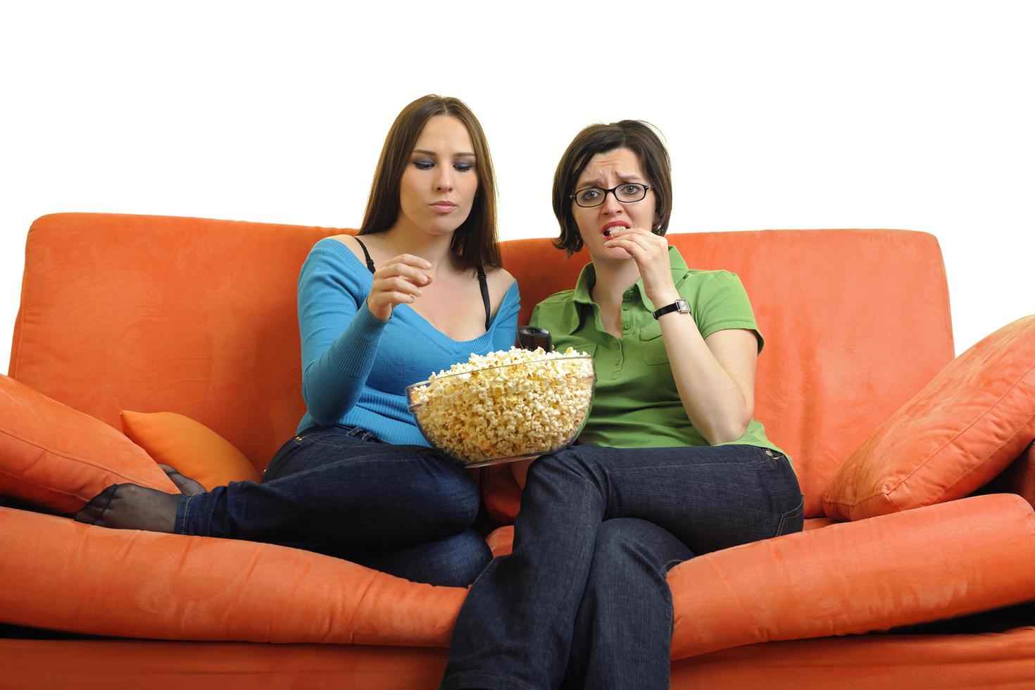 female friends eating popcorn and watching tv at home photo