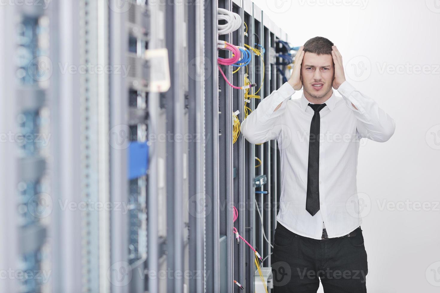 young engeneer in datacenter server room photo