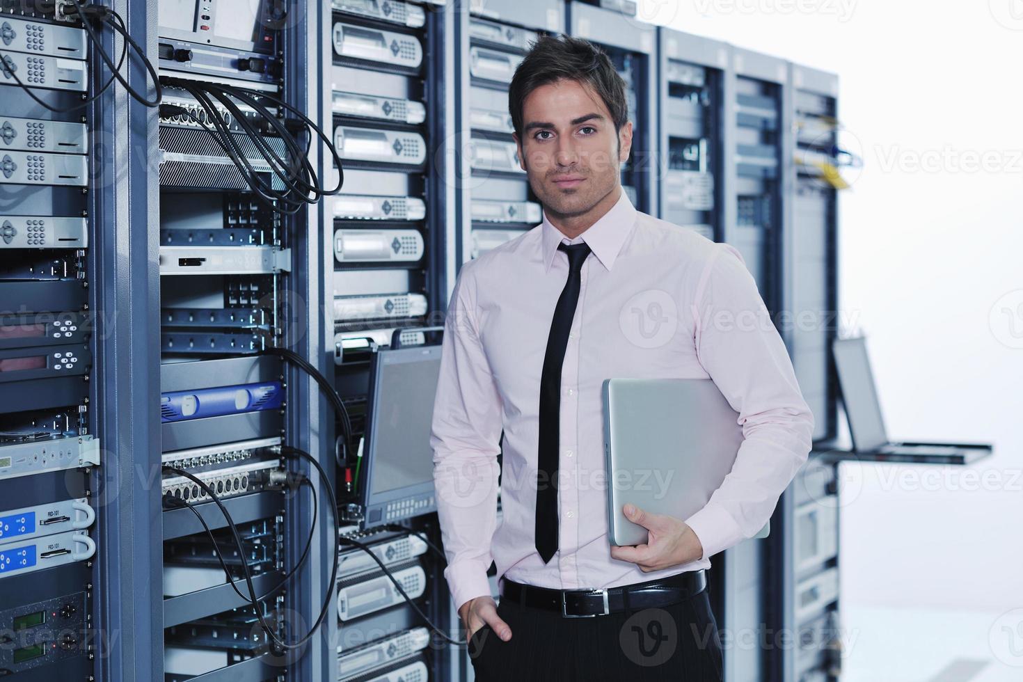 businessman with laptop in network server room photo