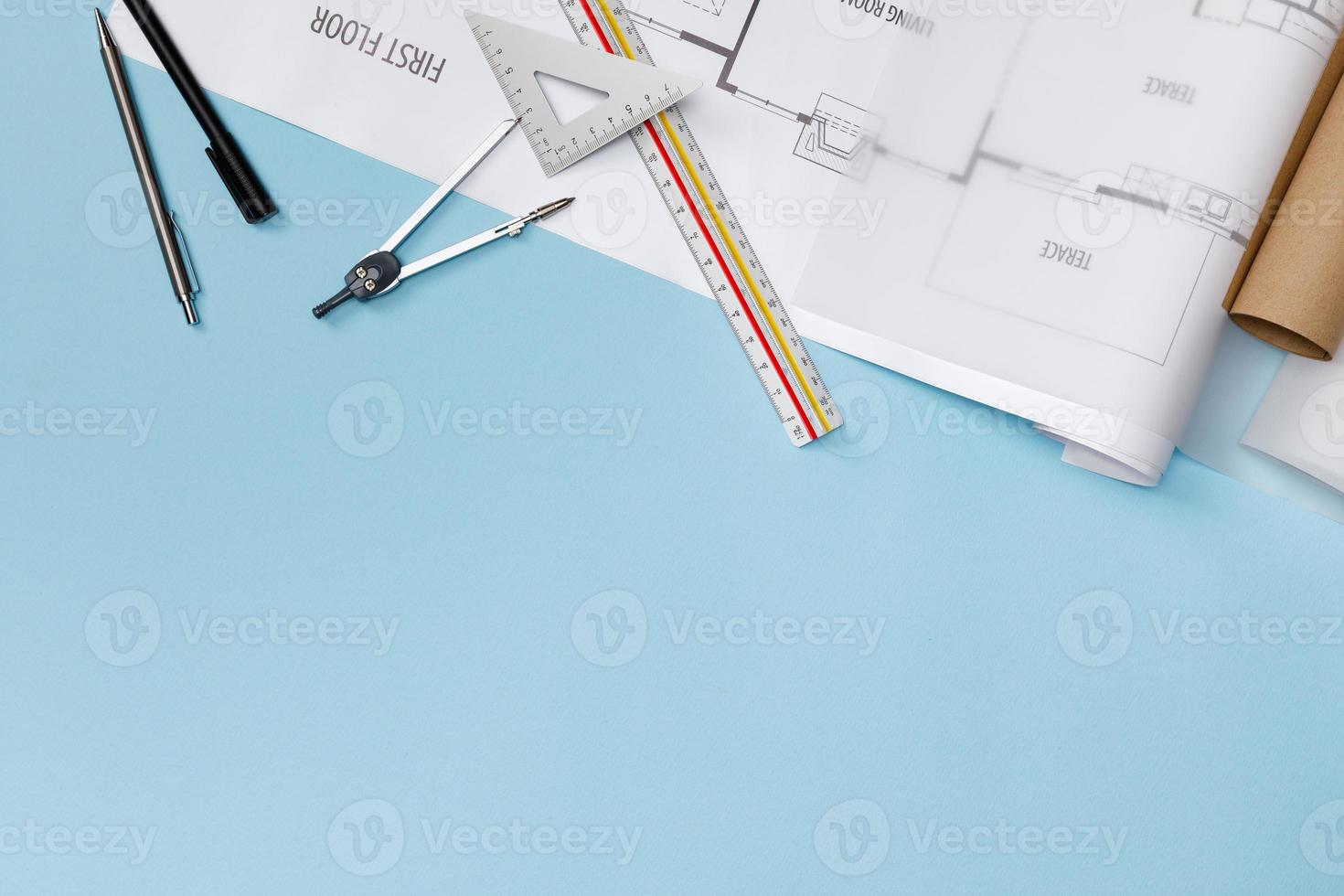 Creative flat lay of architects blue table with roll blueprints, architectural project plan, engineering tools, office supplies, isolated on blue background, Workspace for designer concept photo