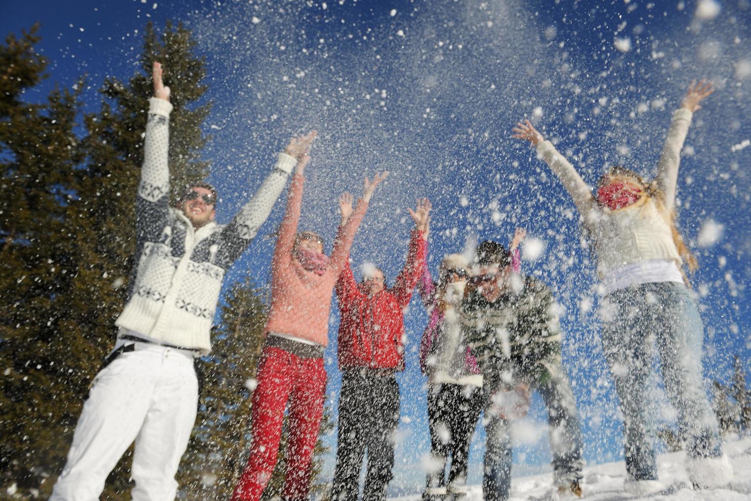 los amigos se divierten en invierno con nieve fresca foto