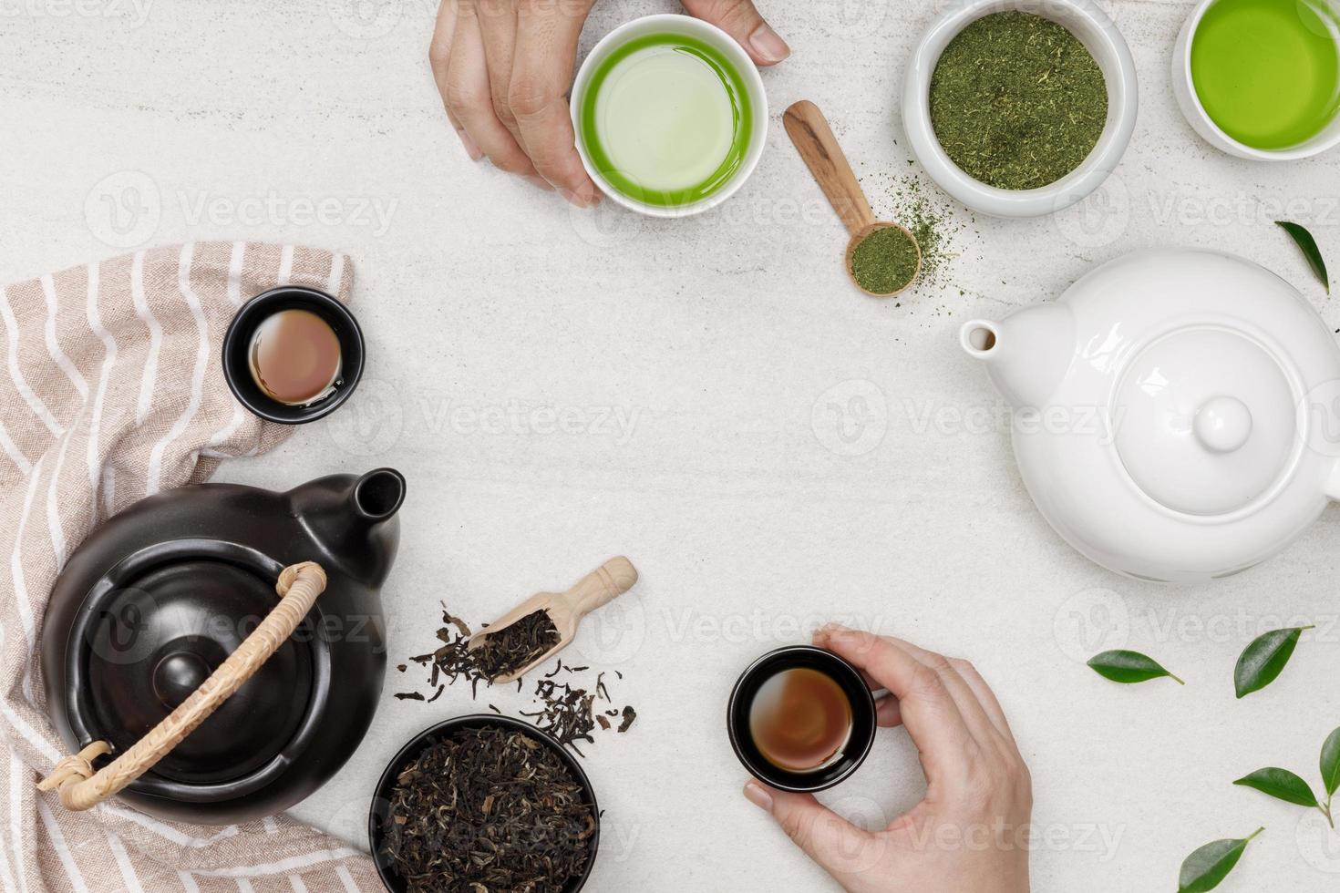 Hands holding hot steaming tea in cup with teapot and dried herb tea on the white stone table creative flat lay, Organic product from the nature for healthy with traditional style photo