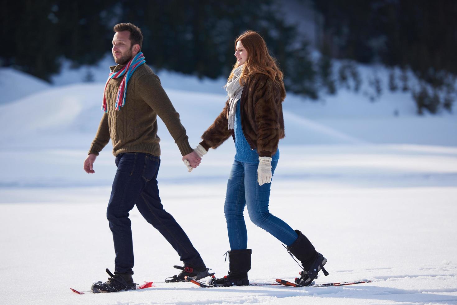 couple having fun and walking in snow shoes photo