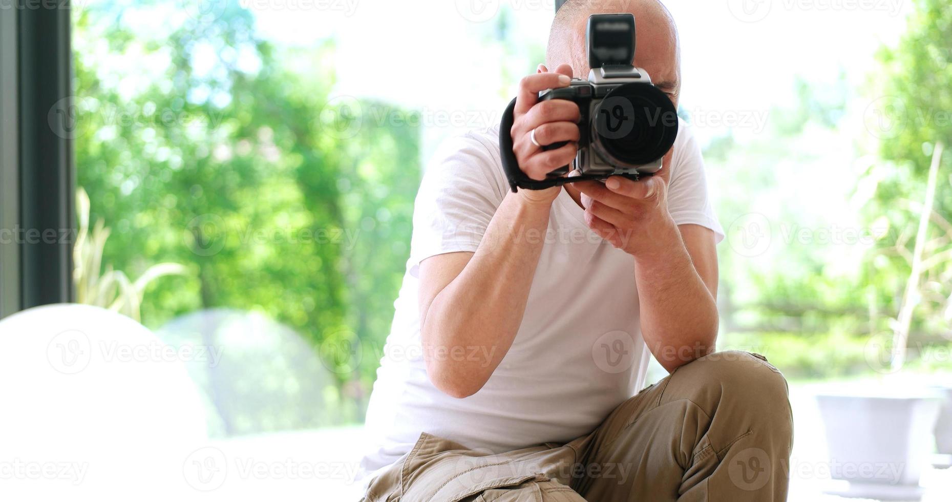 Photographer takes pictures with DSLR camera photo