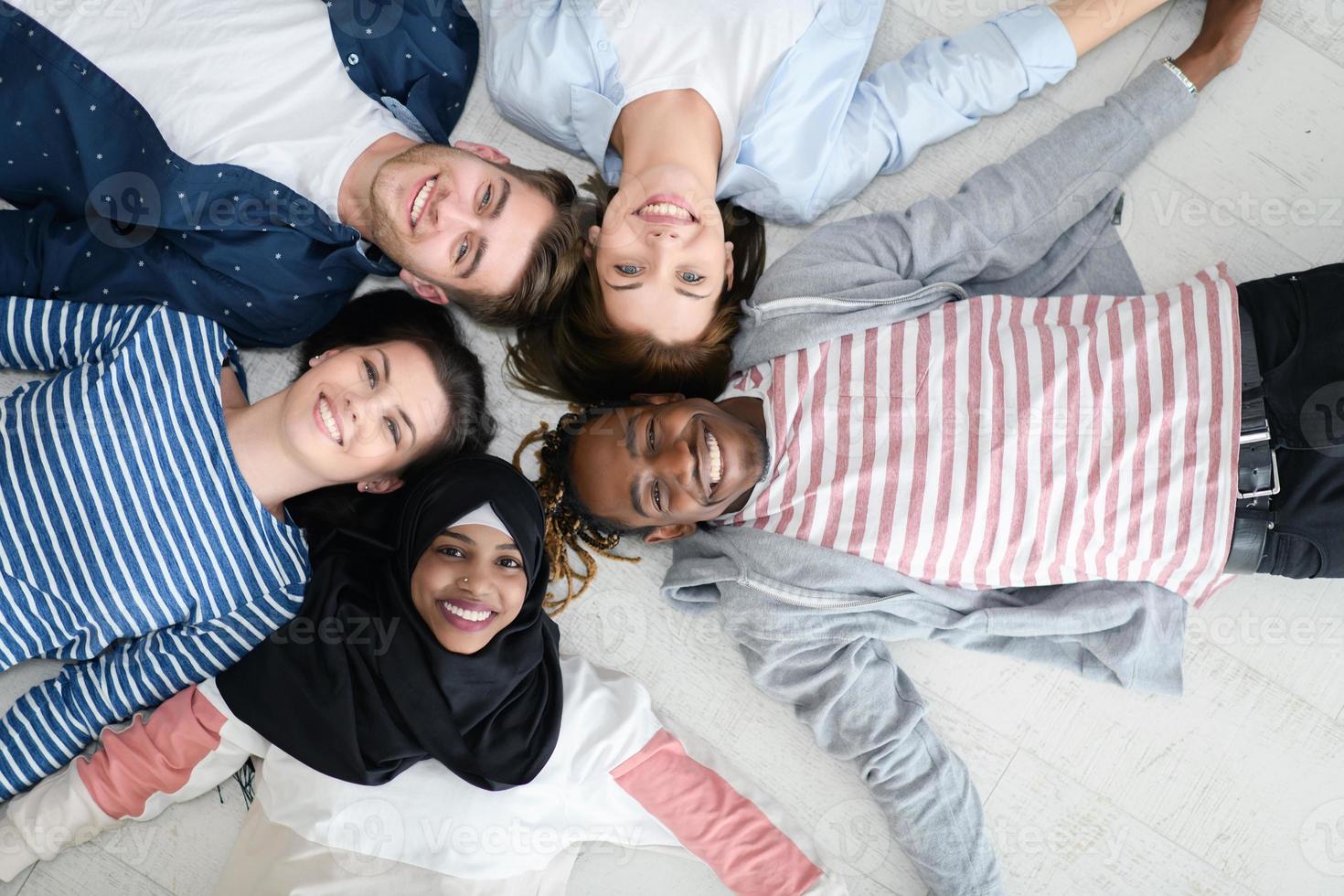 top view of a diverse group of people lying on the floor and symbolizing togetherness photo