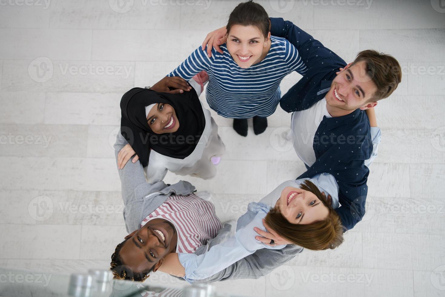 vista superior de un grupo diverso de personas de pie abrazando y simbolizando la unión foto