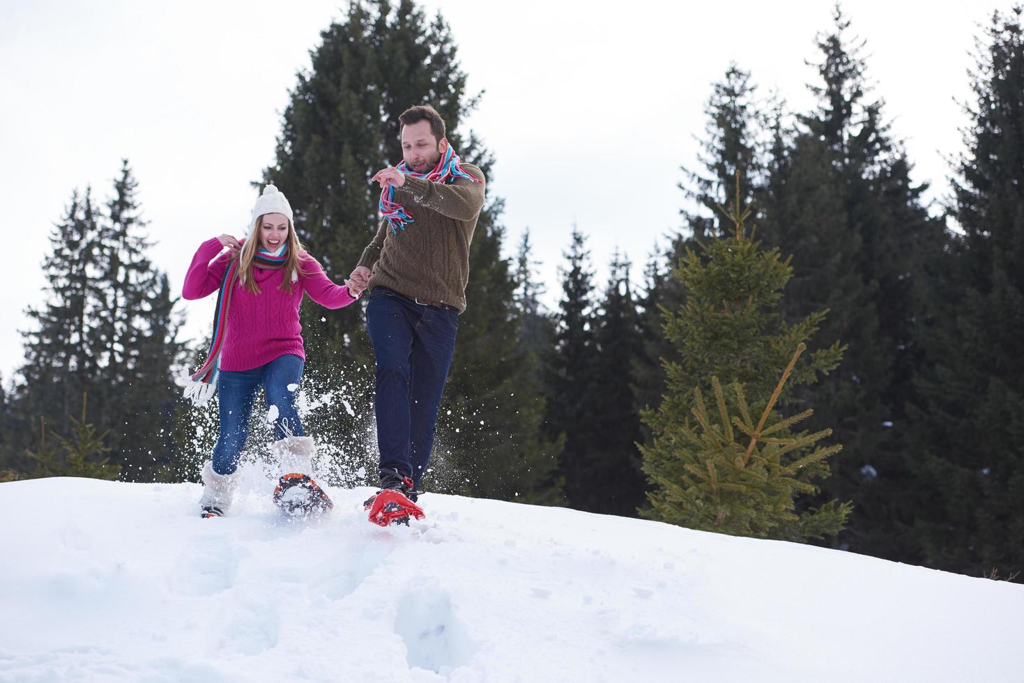 couple having fun and walking in snow shoes photo