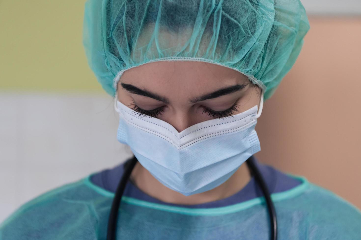 Portrait of sad and overwhelmed doctor wearing protective face mask, looking exhausted depressed and worried due to coronavirus outbreak. Emotional stressed, health care workers and COVID-19. photo