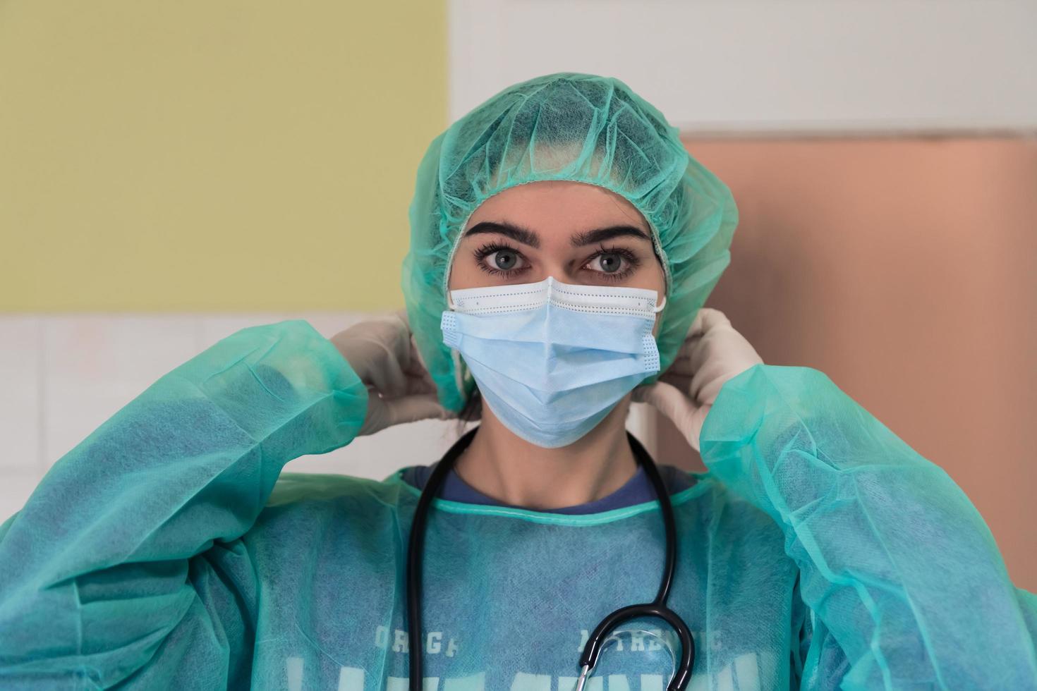 The female animal surgeon or veterinarian puts on a medical face mask. Doctor is preparing for surgery in the operation room. Medicine and healthcare photo