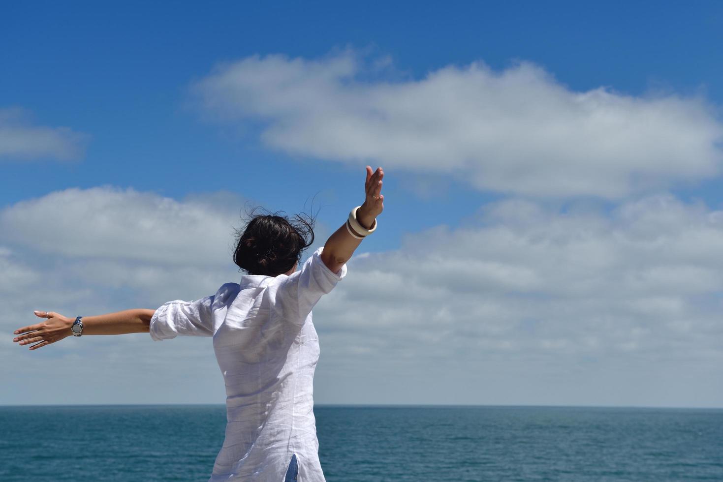 happy young woman with spreading arms to sky photo