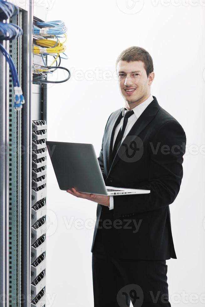 businessman with laptop in network server room photo