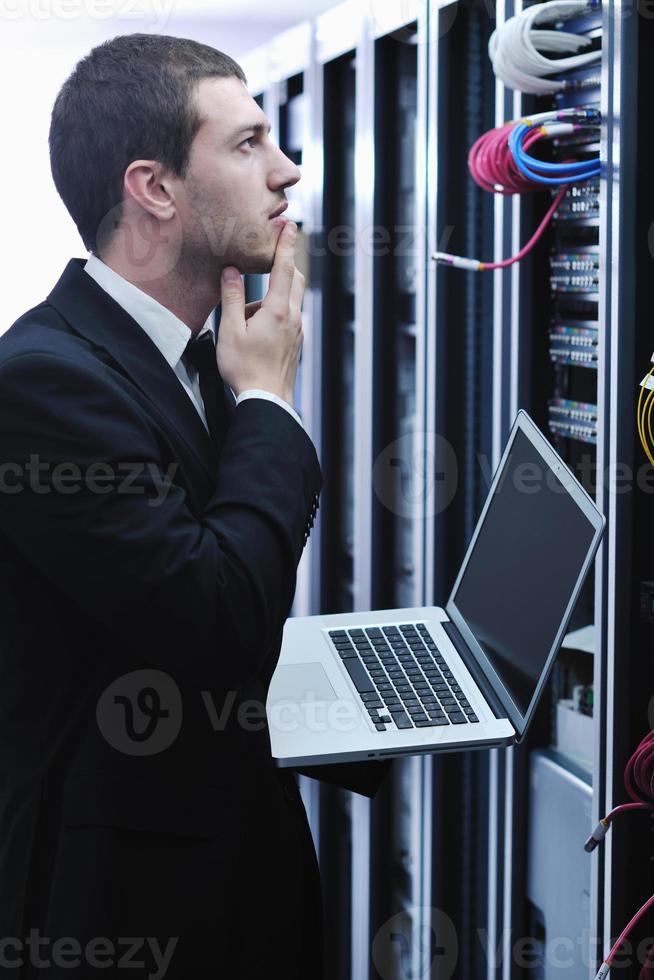 businessman with laptop in network server room photo