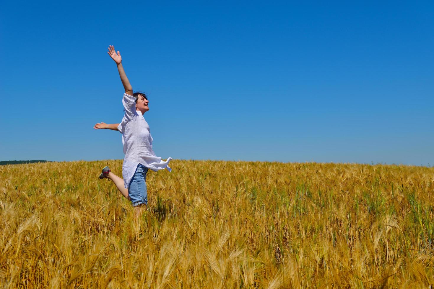 young woman in wheat field at summer photo